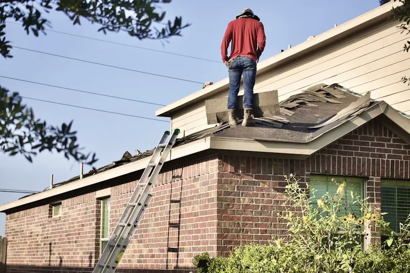 Professional roofer working on a residential roof in Twins of Arden